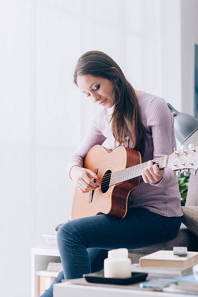 istock Girl playing guitar at home 586945854