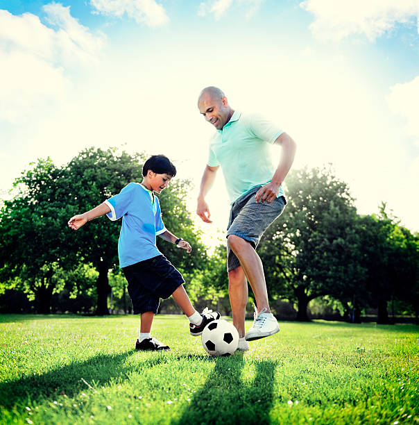 istock Little Boy Playing Soccer With His Father Concept 586946006