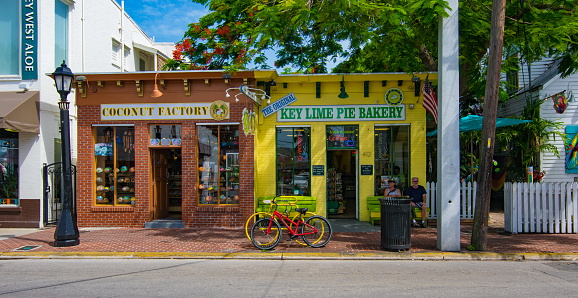 Key West, Florida, USA - August 3, 2016: Tourists on relax on a summer day on the streets of Key West, Florida with colorful storefronts. 