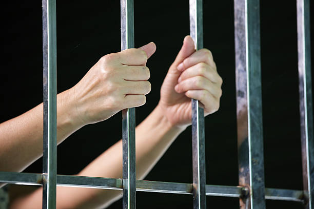 istock hands of prisoner in jail 587184486