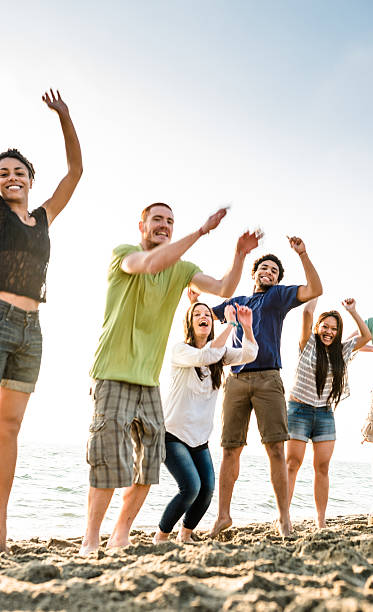 istock group of friends jumping on the beach 587185050