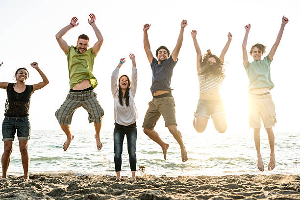 istock group of friends jumping on the beach 587185198