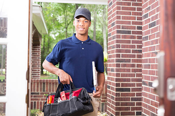 istock African descent repairman at customer's front door. 587186164