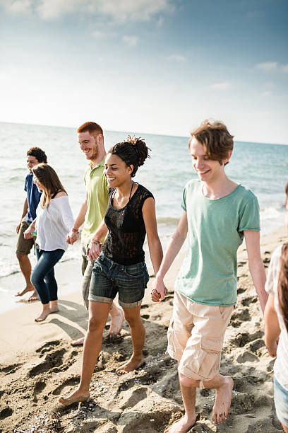 istock group of friends walking on the beach togetherness 587186320