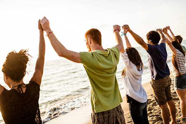 ボランティアに盛り上がった夕暮れの腕 - assistance holding hands friendship human hand ストックフォトと画像