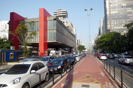 Sao Paulo, Brazil - July 30, 2016: Paulista Avenue view with like lane, transit and the Art Museum of Sao Paulo, MASP on one side and across the Trianon Park.