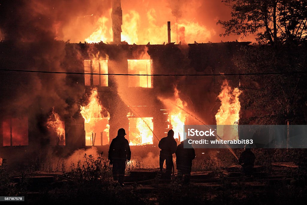 firefighters silhouettes on fire background silhouettes of  firefighters on on burning house background Fire - Natural Phenomenon Stock Photo