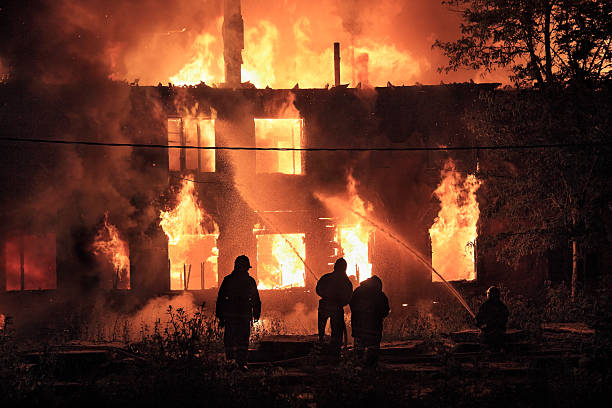 silhuetas bombeiros em fundo de fogo - house fire - fotografias e filmes do acervo