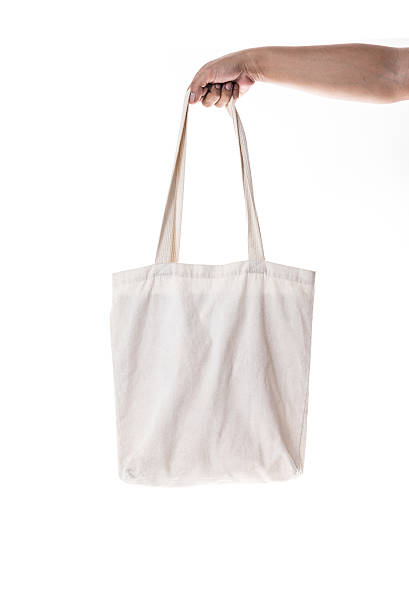 istock Hand holding cotton eco bag on white background 587189816