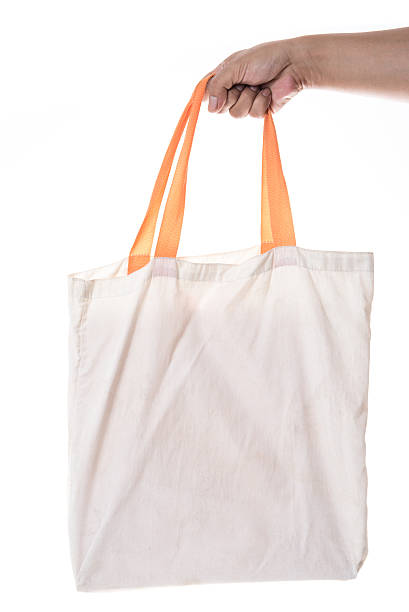 istock Hand holding cotton eco bag on white background 587189910
