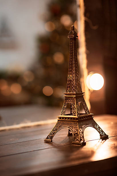 istock Miniature Eiffel-tower with defocused spot lights in background 587190018