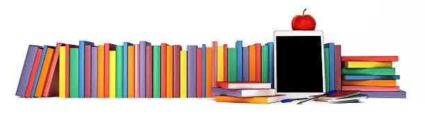 Photo of colorful books, tablet, school supplies and an apple