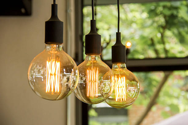 Glowing retro light bulbs hanging from ceiling stock photo