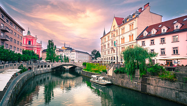 Slovenia Ljubljana Tromostovje Ljublianica river Church Slovenia Ljubljana Tromostovje Ljublianica river Church with bridge and boat. slavic culture photos stock pictures, royalty-free photos & images