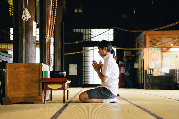istock Japanese couple praying in a buddhist temple 587193114