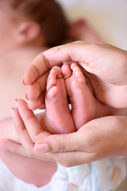 istock tiny foot of newborn baby 587194158