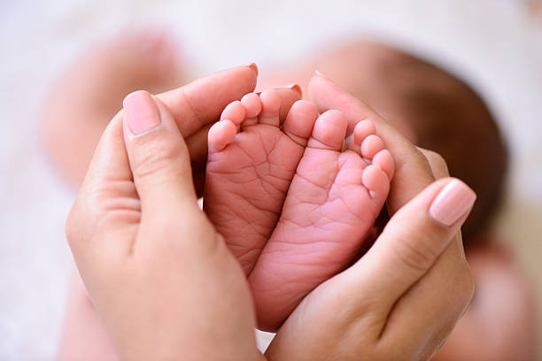 winzige neugeborene babys füße auf  - menschlicher fuß fotos stock-fotos und bilder