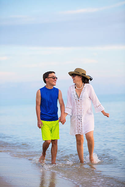 istock Mother and son walking on the beach 587194656