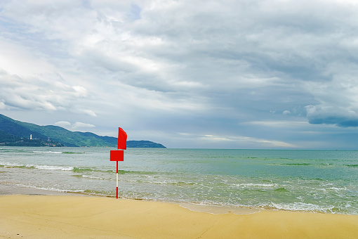 Flag at the China Beach in Danang in Vietnam. It is also called Non Nuoc Beach. South China Sea and Marble Mountains on the background.