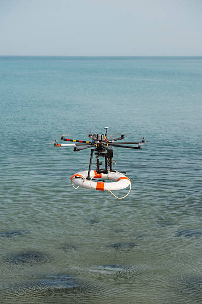 istock Flight of rescue drone carrying lifebuoy. 587196262