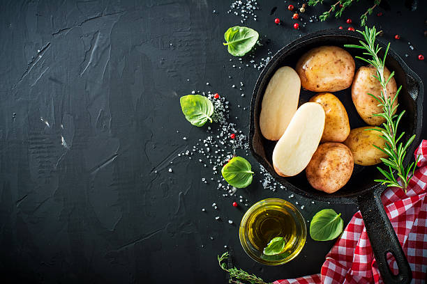 istock Young ripe potatoes in a black cast iron pan with 587197464