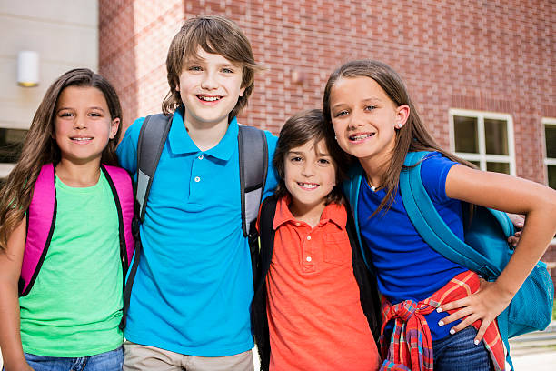 istock Elementary-age children, friends on school campus going back to school. 587198352