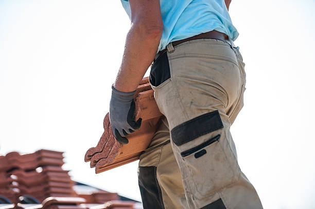 istock Tiler covering roof with new tile 587198972