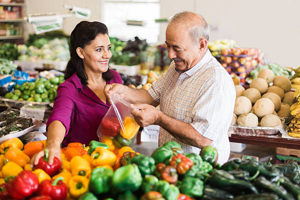 donna matura e uomo anziano che fanno shopping al supermercato - senior adult aging process supermarket shopping foto e immagini stock