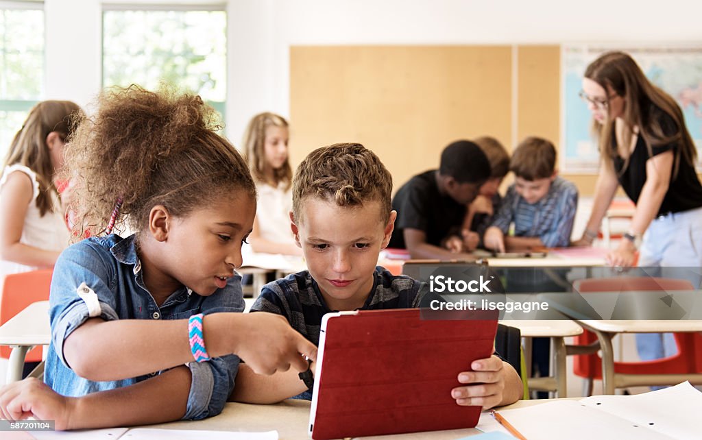 School kids in class using a digital tablet Classroom Stock Photo