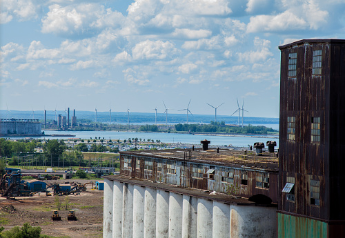 Old Grain elevator in the foreground contrasts with new windmills in the background on Lake Erie in Buffalo.