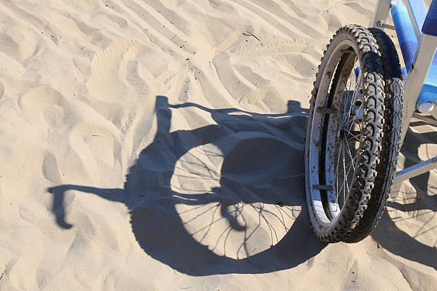 shadow of a wheelchair on the beach sand