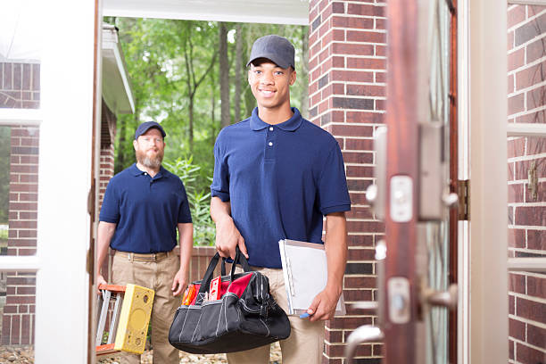 istock Multi-ethnic repairmen at customer's front door. 587203032