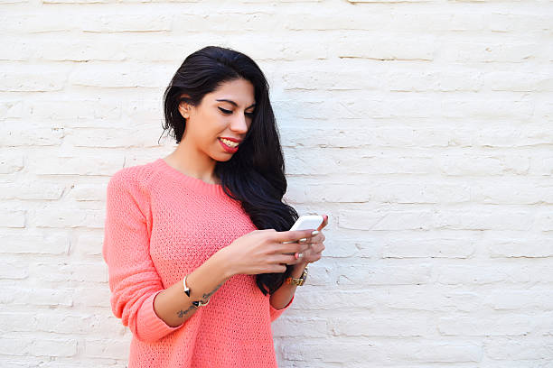 istock Young latin woman using her cellphone 587204542