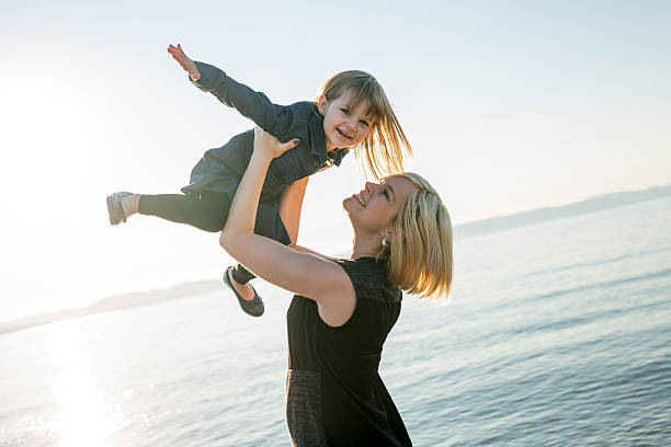 istock Mother and daughter on the beach side having fun 587205840