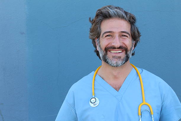 Portrait of a smiling handsome doctor Portrait of a smiling handsome doctor with salt and pepper hair. hot handsome man stock pictures, royalty-free photos & images