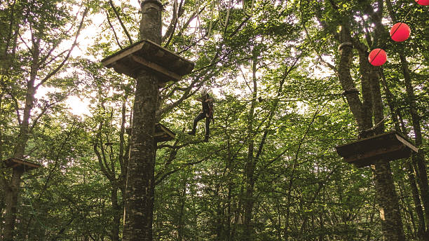 acrobranch: corda scalatore che cammina un passo alla volta - climbing clambering hanging rope foto e immagini stock