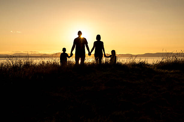 istock family of four at sunset shadow black backlit 587207692