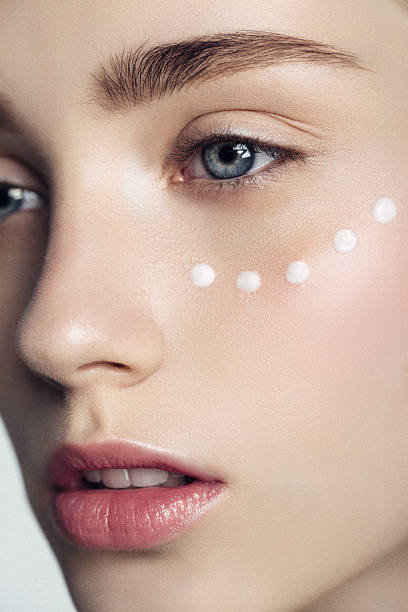 istock Beautiful woman with cream dots on the face 587208120