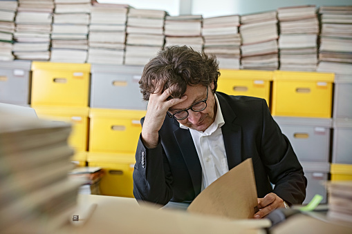 Frustrierter Geschäftsmann Sitzt Am Schreibtisch Mit Papierkram ...