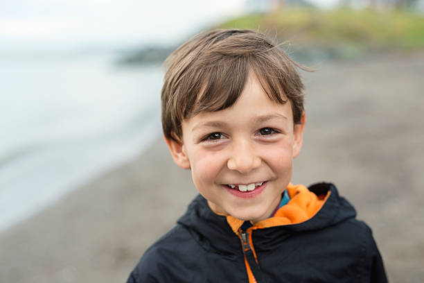 istock boy enjoying the rain and having fun outside on the 587218246