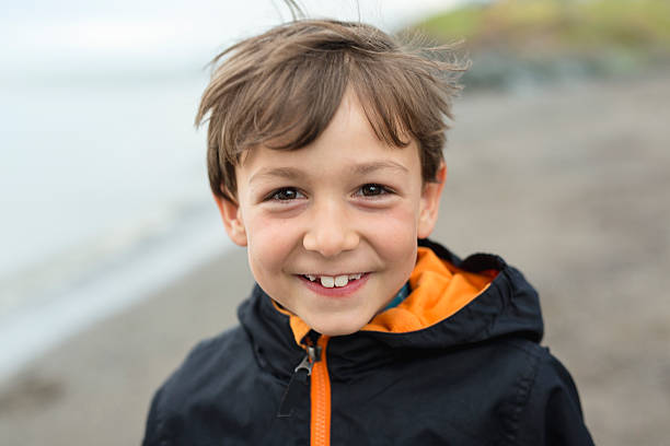 istock boy enjoying the rain and having fun outside on the 587218282