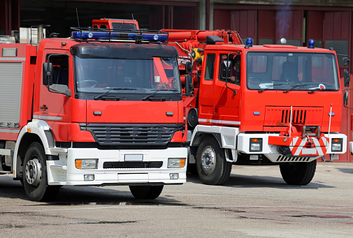 two truck fire engines firefighters during a fire drill training in the barracks of the fire brigade