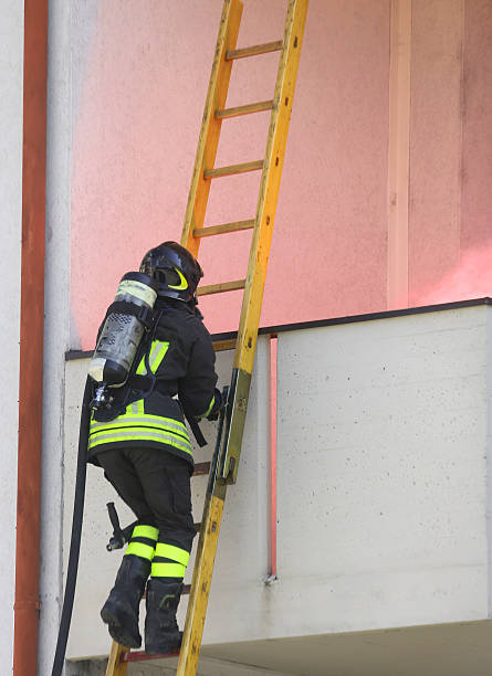 istock Firefighter with oxygen cylinder climbing a wooden ladder 587220358