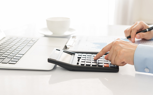 Businessman using a calculator to calculate the numbers. Accounting , Accountancy, Calculation Concept.