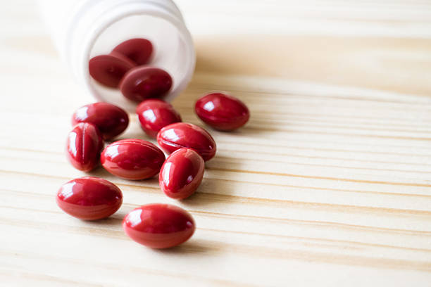 istock Red pills and white bottle on wooden background,selective focus. 587223870