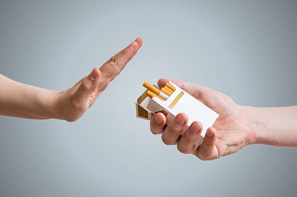 smettere di fumare concetto. la mano rifiuta l'offerta di sigarette. - tobacco foto e immagini stock
