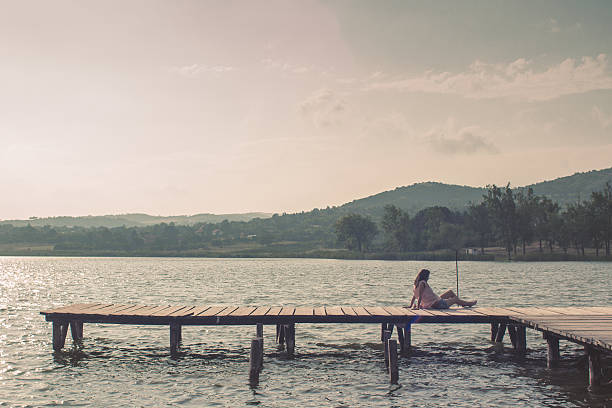 istock Lonely girl on the dock 587225236