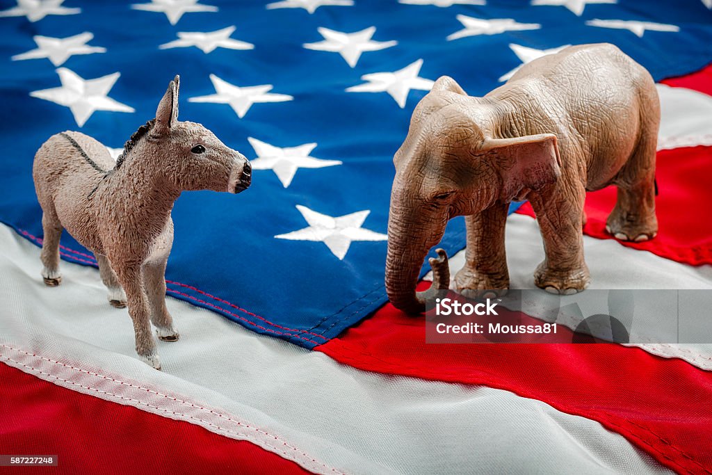 Political face off in November Democrats vs republicans are facing off in a ideological duel on the american flag. In American politics US parties are represented by either the democrat donkey or republican elephant US Republican Party Stock Photo
