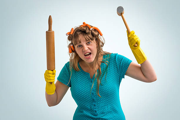 istock Crazy housewife with kitchen roller and meat hammer 587227314
