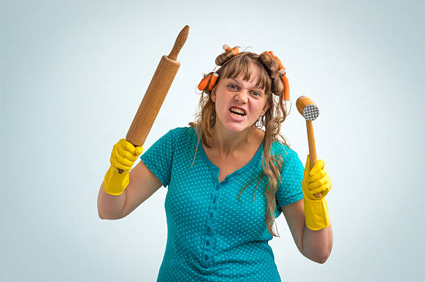 istock Crazy housewife with kitchen roller and meat hammer 587227366